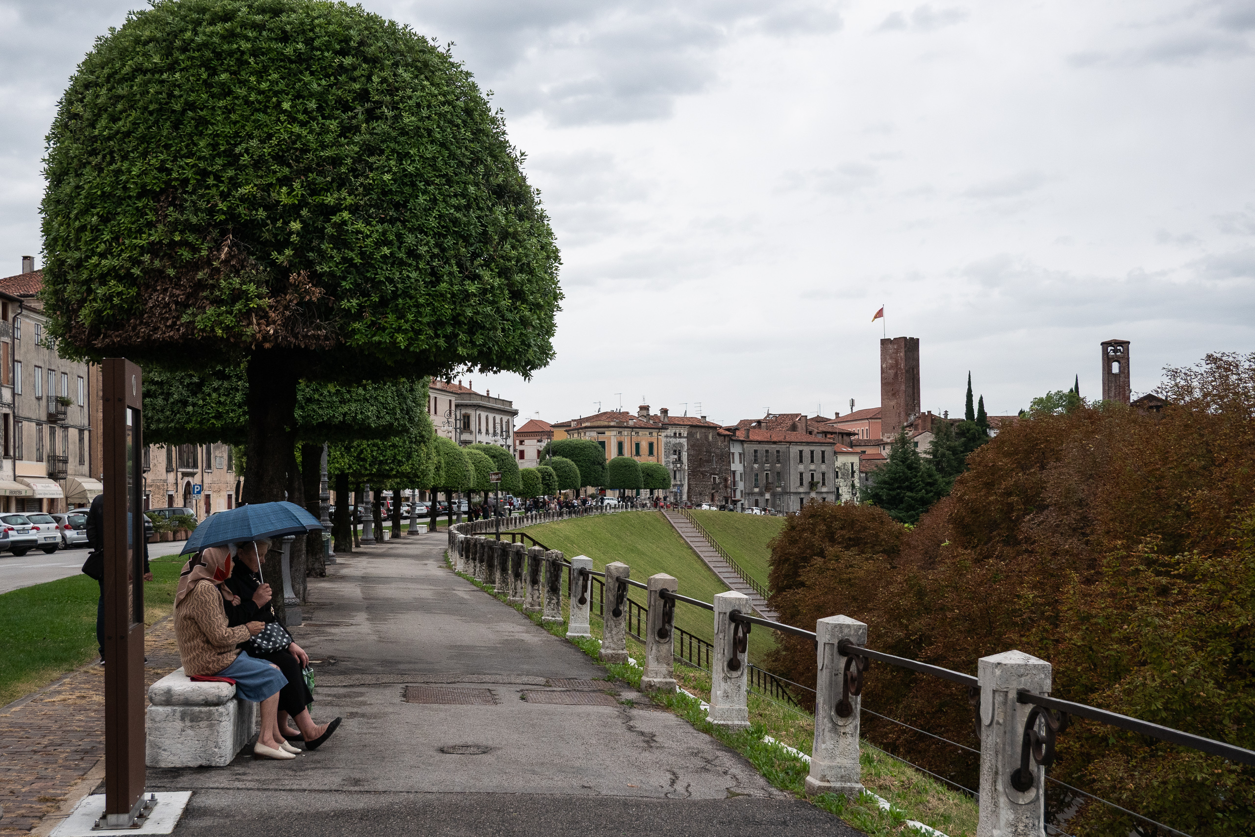 Unter den Kugelbäumen auf der Stadtmauer von Bassano – zwei Frauen im Regen
